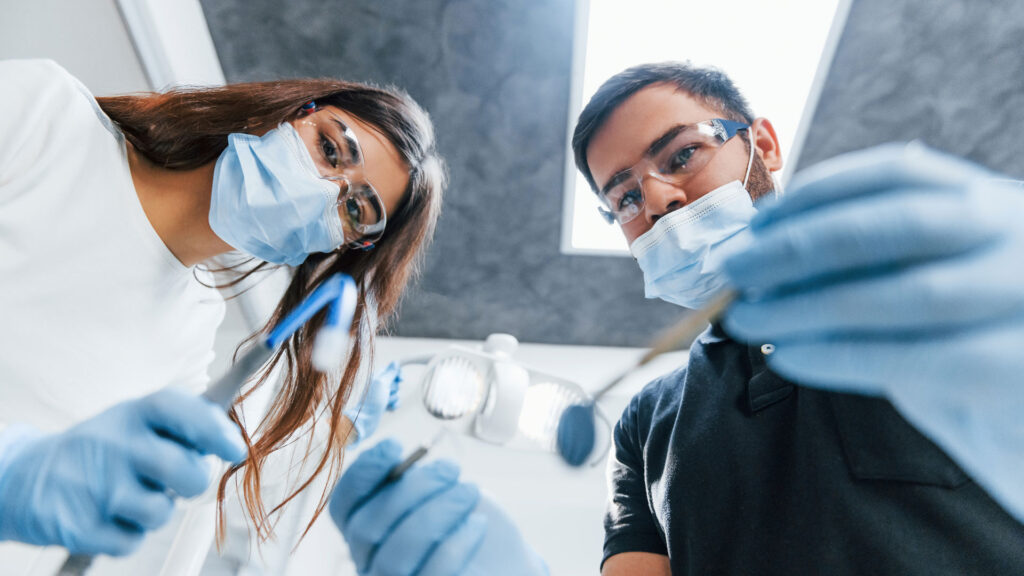 Male and female dentists working in the office together. First person view. m360 Research. Insights into Dental Therapy in Canada.